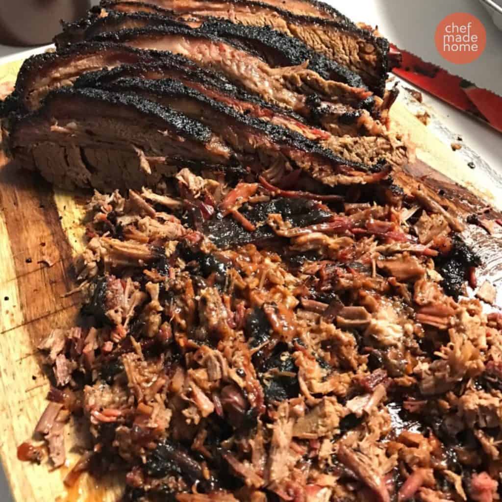 Smoked Brisket on a wooden cutting board with chopped brisket in the front and sliced brisket in the back.