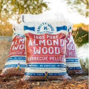 3 bags of almond wood pellets sit on fall foilage