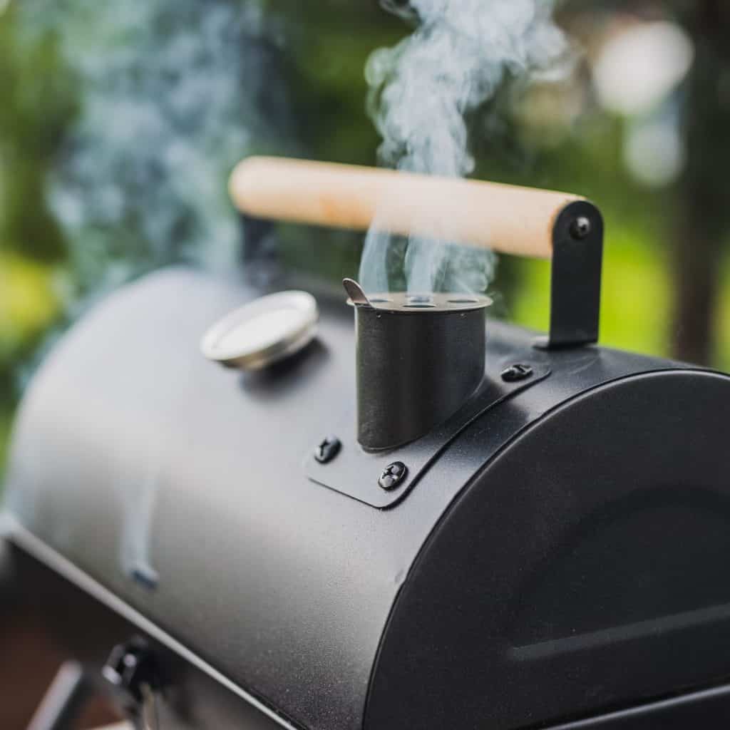 Small BBQ Grill and Smoker with blue smoke